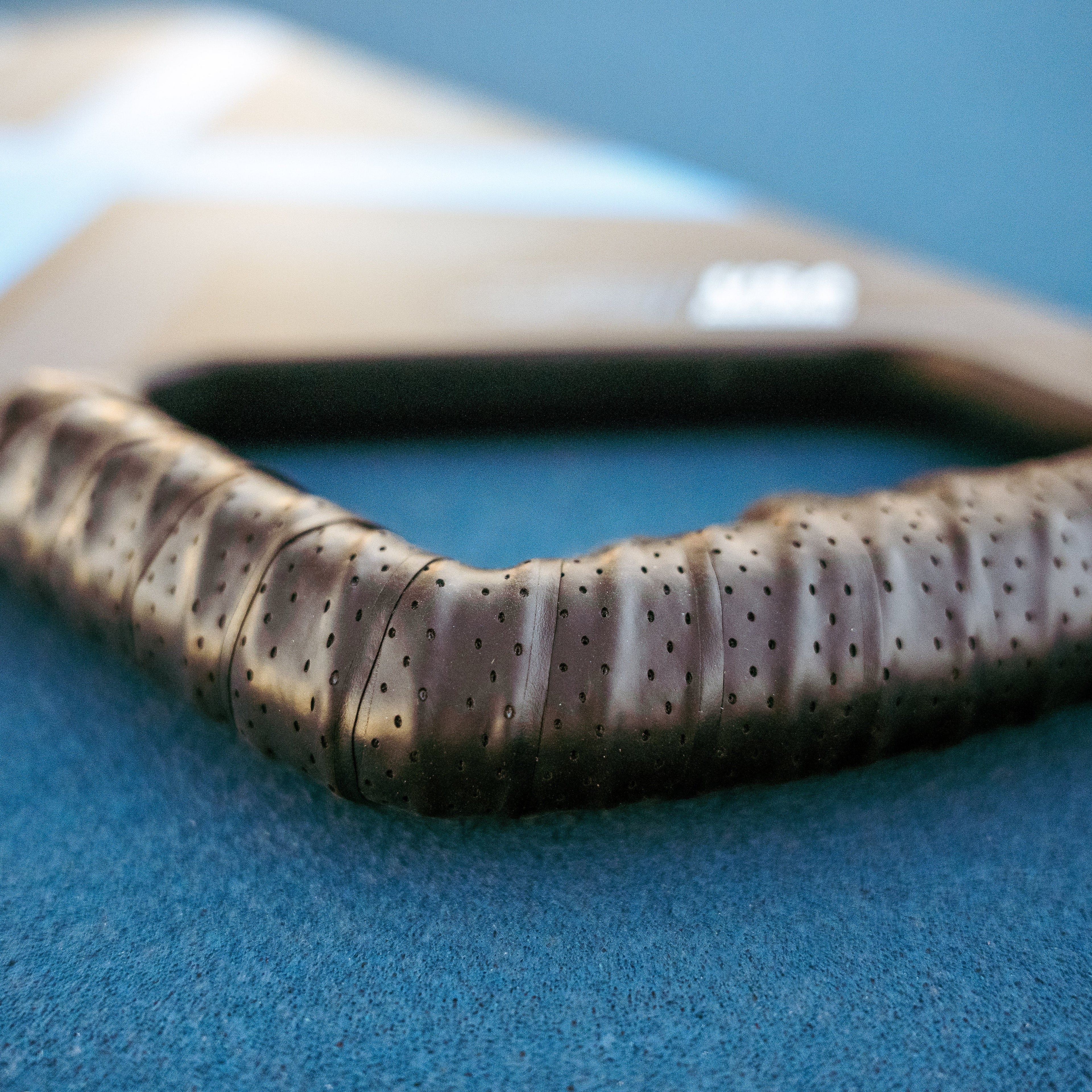 Side view of the Xcaliber Ergo pickleball paddle showing the angled pistol grip handle design